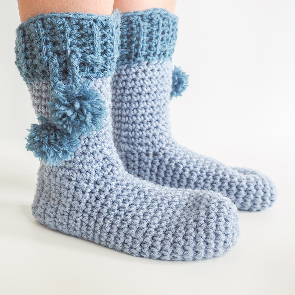 The Pom Pom Slipper Socks make adorable stocking stuffers. #crochetsocks #crochetslippers #crochetpattern #crochetaddict #crochetlove