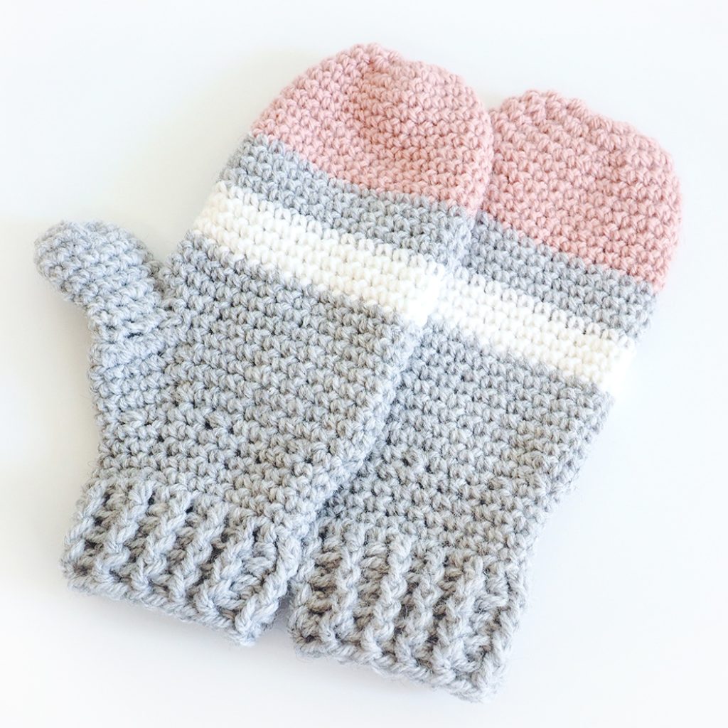 These striped crochet mittens are perfect for a day spent in a winter wonderland. This free crochet pattern will keep you warm and cozy. #CrochetMittens #CrochetPattern #CrochetGloves #CrochetAddict 