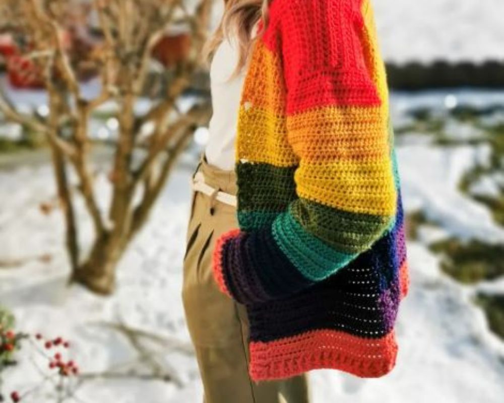 Woman wearing rainbow striped crochet cardigan