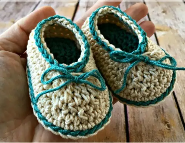 person holding crochet baby booties