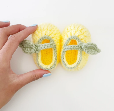 woman holding crochet lemon booties